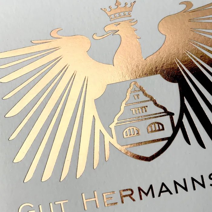 Gold foil embossed eagle emblem with crown and shield design