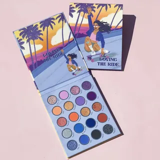 Eyeshadow palette with colorful shades and sunset artwork by Alex Cabal