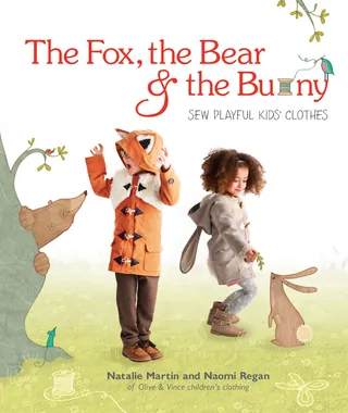 Kids wearing fox and bunny costumes standing with animal illustrations