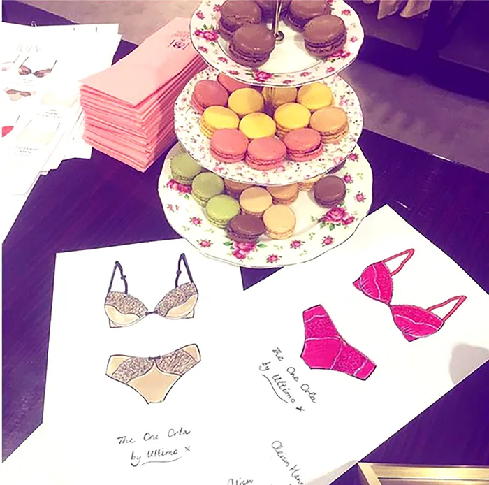 Three-tiered plate with macarons on table with underwear sketch papers