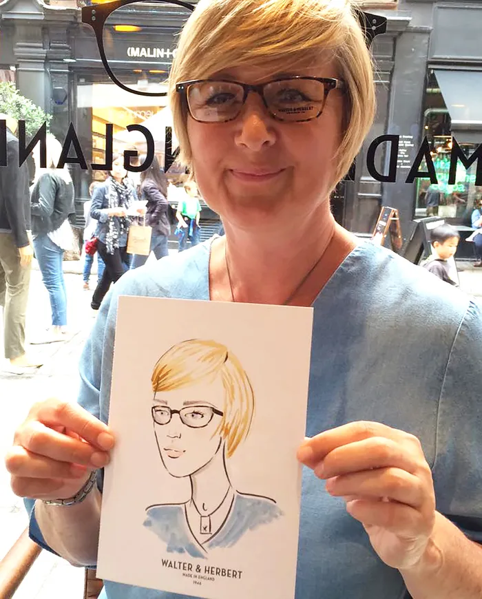 Woman holding her hand-drawn portrait