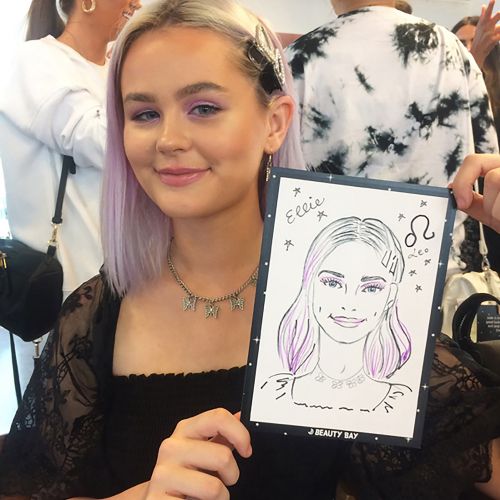 Young woman holding a caricature portrait at an event