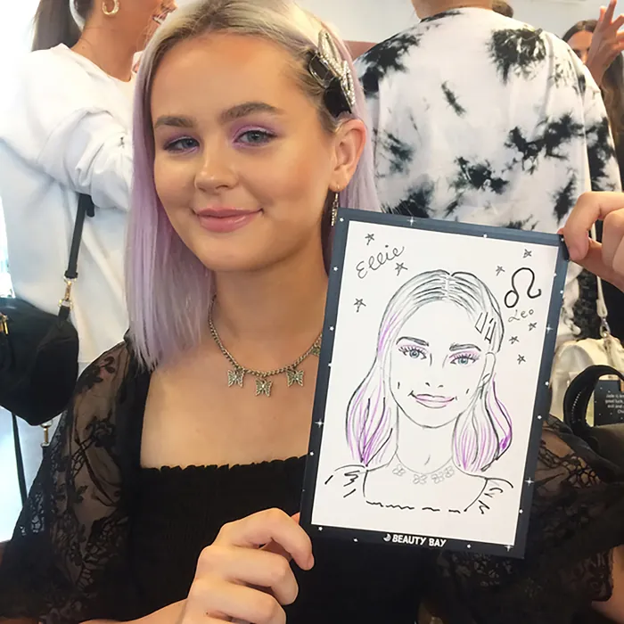 Young woman holding a caricature portrait at an event