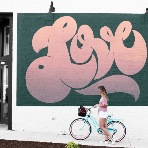Graphic lettering Girl with bicycle at love sign
