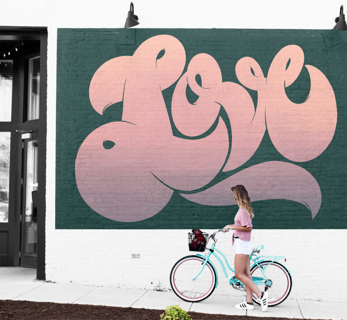 Lettrage graphique Fille avec vélo au signe de l&#39;amour