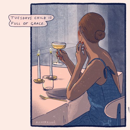 Woman in blue dress holding a glass by candlelit dinner table