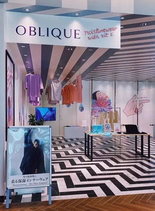 Retail store showcasing hanging clothes and geometric black and white floor design