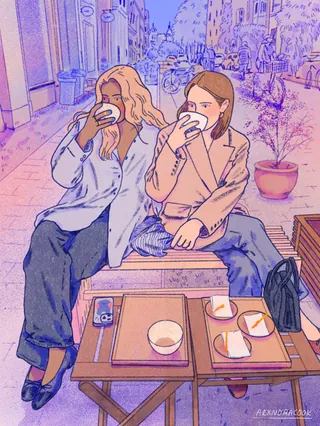 Two women drinking coffee at an outdoor café in the city