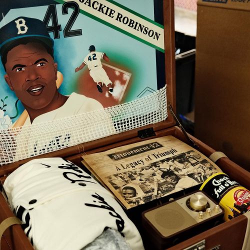 Mural of Jackie Robinson playing baseball with memorabilia inside a briefcase