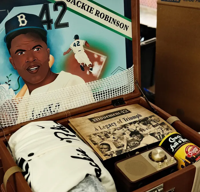 Mural of Jackie Robinson playing baseball with memorabilia inside a briefcase