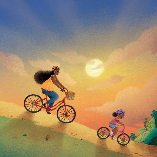Family riding bicycles on a hill during a sunset