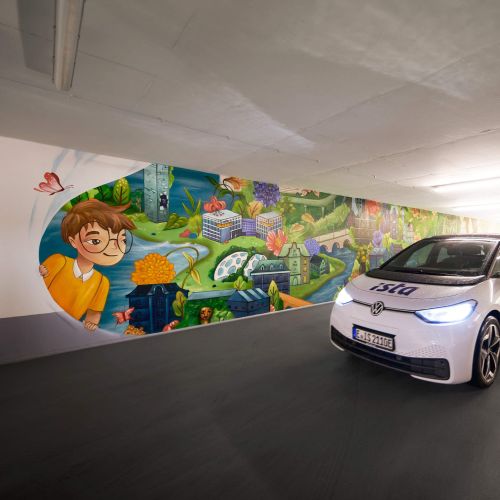 Electric car in underground parking with colorful mural by Alyssa De Asis