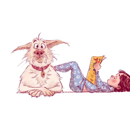 Child reading book next to friendly dog lying on floor