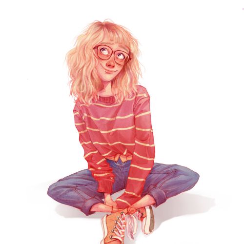 Smiling girl with glasses sitting cross-legged wearing striped sweater and jeans