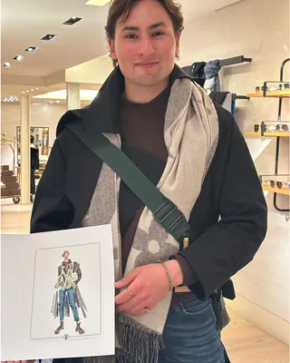 Man holding fashion illustration inside Louis Vuitton store