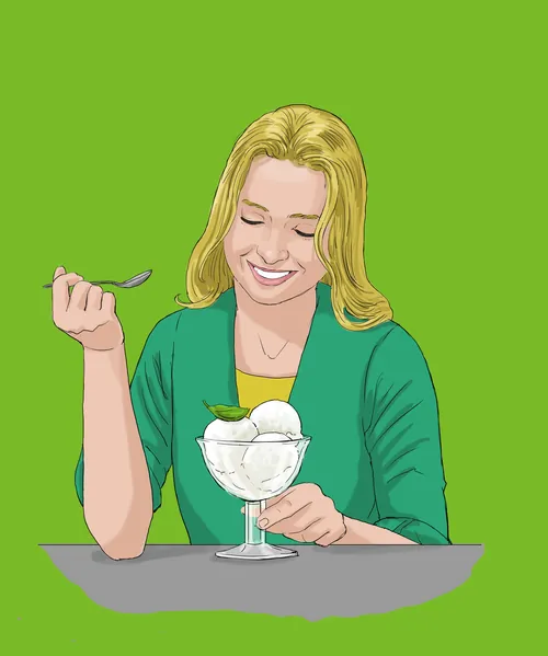 Woman enjoying a glass bowl of vanilla ice cream dessert by Andreas Schickert