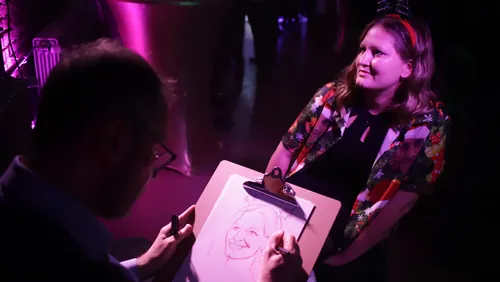 Artist drawing a woman's portrait with soft purple lighting