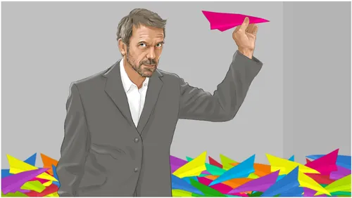 Man in suit holding pink paper plane with colorful planes on ground by Andreas Schickert