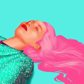 Woman with pink hair lying down with a tear on her cheek