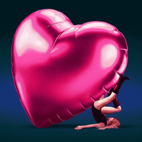 Woman lying down holding large pink heart balloon