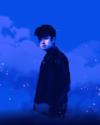 Young man standing with blue sky and clouds background