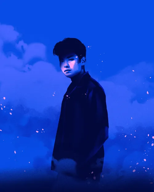 Young man standing with blue sky and clouds background