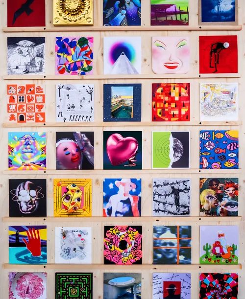Wall display of colorful abstract and portrait artworks by Andrei Nicolescu