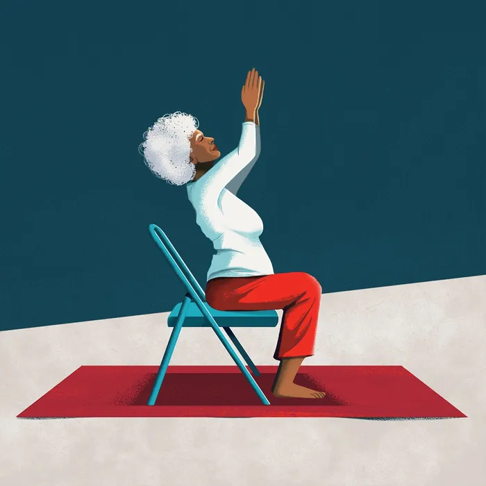 Elderly woman doing seated yoga stretch on chair and mat