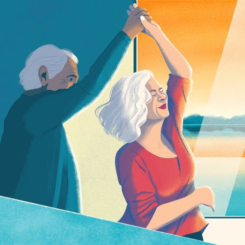 Senior couple dancing happily near a sunlit window