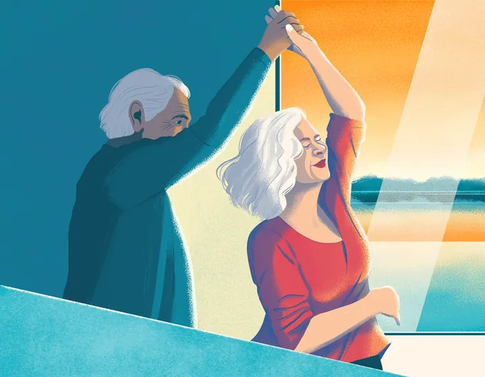 Senior couple dancing happily near a sunlit window