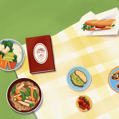 Table with diverse dishes and a menu on a yellow checkered tablecloth.
