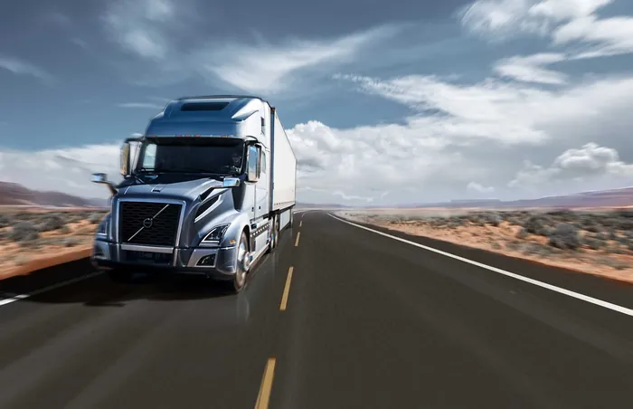 Blue semi truck driving on desert highway by Andriy Vynogradov