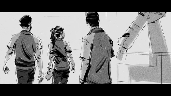 Three individuals looking at a large robotic arm in a workspace.