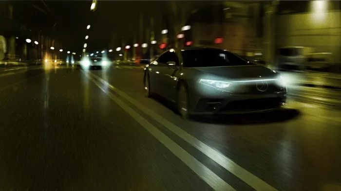 Black sports car speeding on city road at night