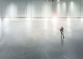 A lone person standing in a large empty industrial space with bright lights by Andriy Vynogradov