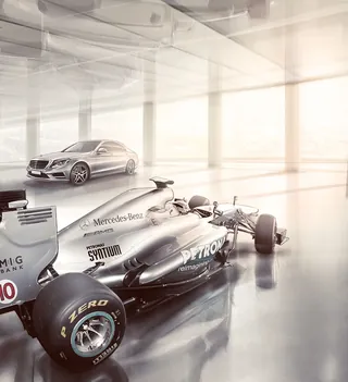 Mercedes-Benz Formula 1 car and luxury sedan in bright showroom by Andriy Vynogradov