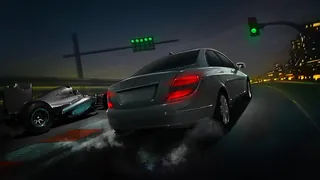 Nighttime street race with two cars under green traffic lights by Andriy Vynogradov