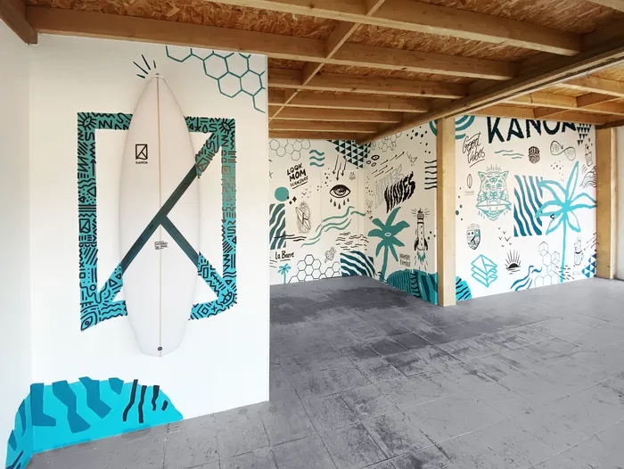 Surfboard mounted on patterned wall with wooden ceiling beams by Andy Gellenberg