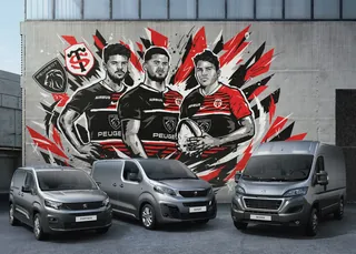 Mural of rugby players in Peugeot jerseys with three Peugeot vans parked below by Andy Gellenberg