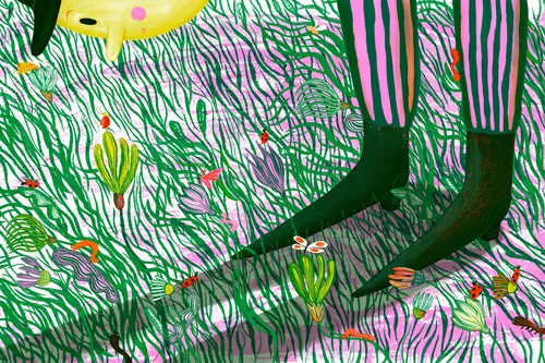 Child's legs in striped pants standing in grass with colorful flowers