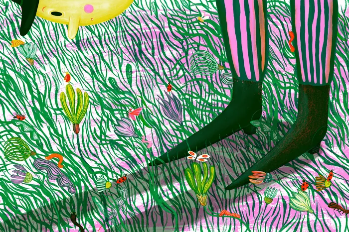 Child's legs in striped pants standing in grass with colorful flowers