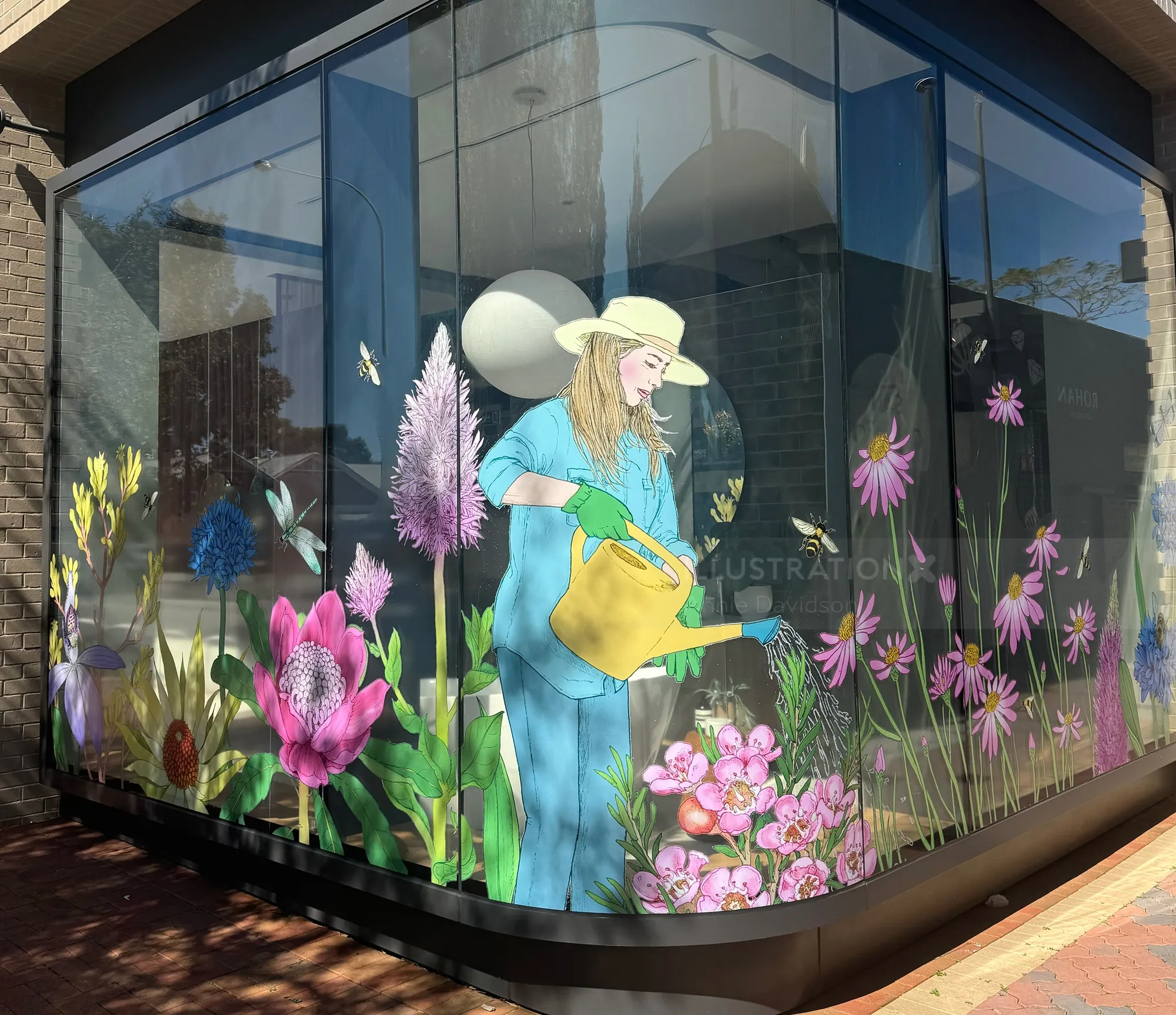Window decals showing woman watering flowers by Annie Davidson