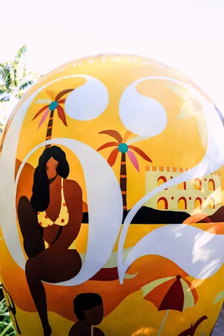 Beach scene illustration with woman, palm trees, umbrellas, and number 62