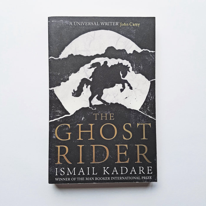 Cover of Ismael Kadare's The Ghost Rider, with linocut illustration of a man and woman on a rearing 