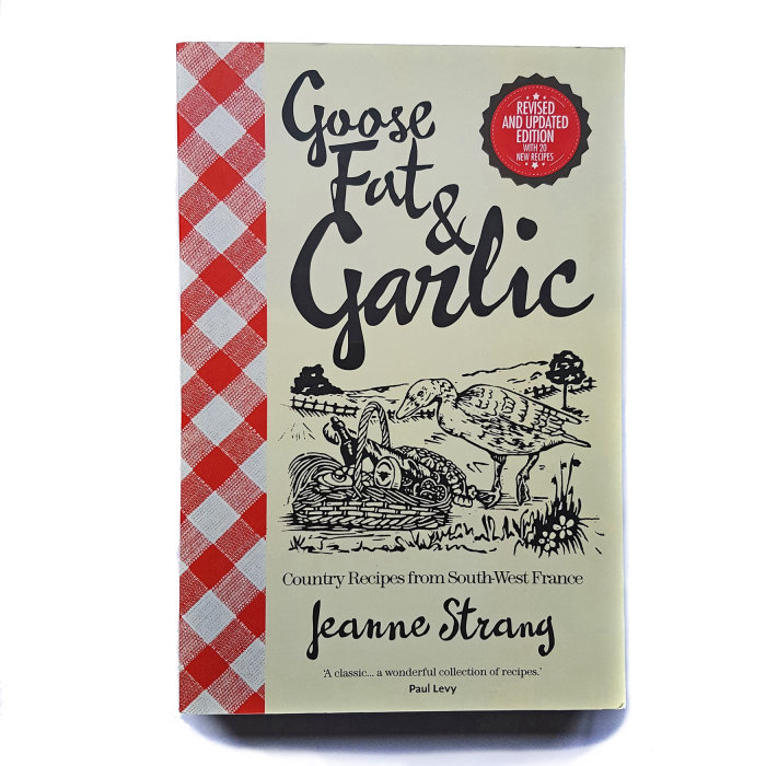 Couverture de Jeanne Strang&#39;s Goose Fat &amp; Garlic, avec une illustration en linogravure d&#39;une oie debout près d&#39;un ha