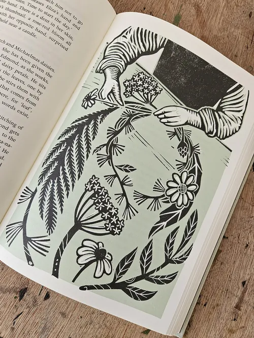 Linolschnittillustration von Händen, die einen Blumenkranz binden, von Becca Thorne