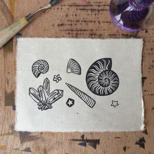 Black and white linocut print of fossils and minerals by Becca Thorne