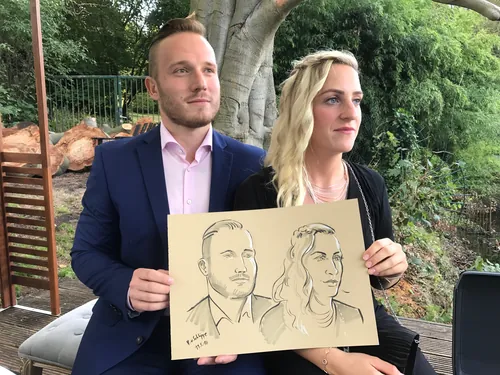 A man and woman hold a portrait drawing by Björn von Schlippe
