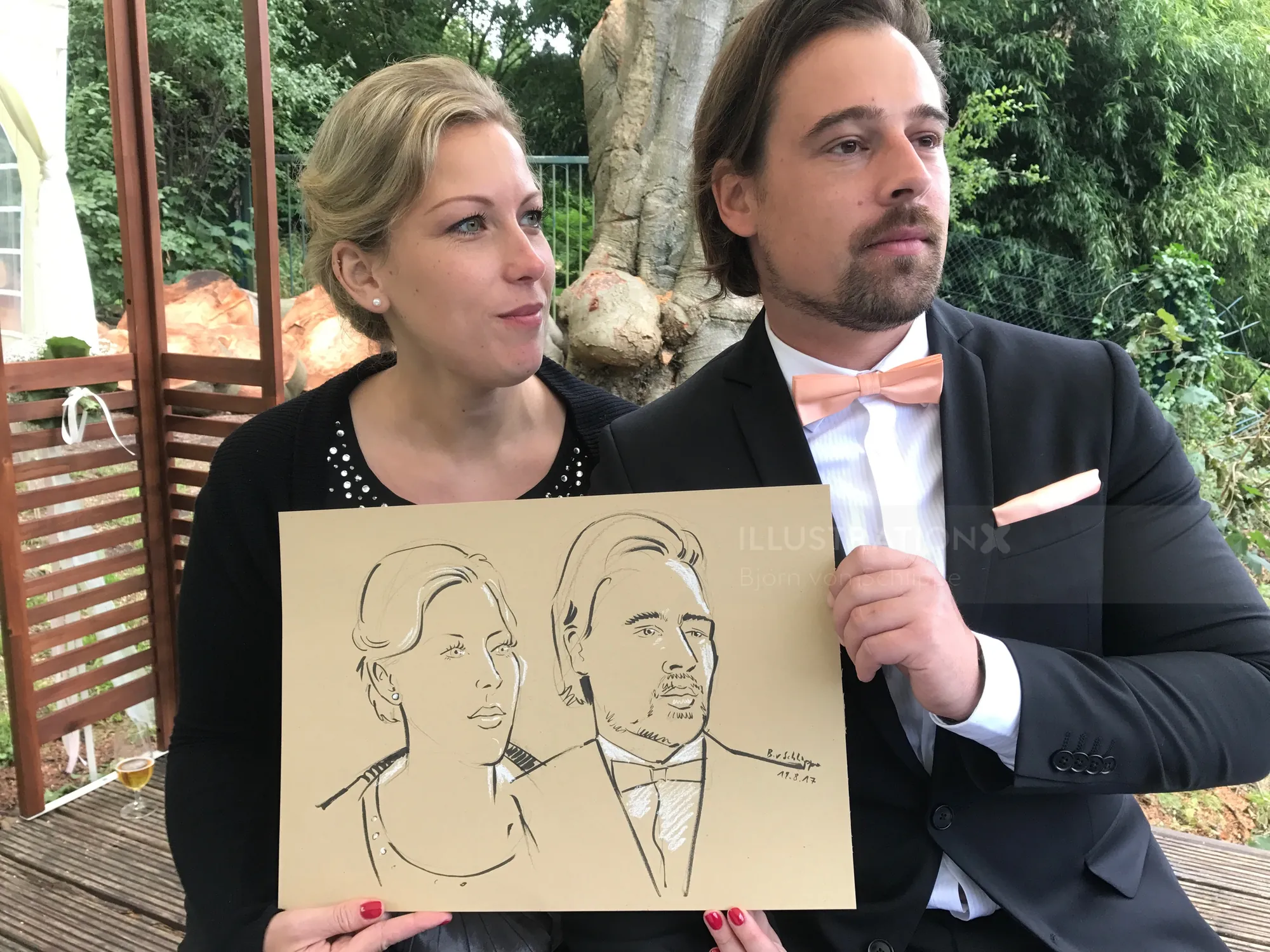 Man and woman holding caricature drawing by Björn von Schlippe