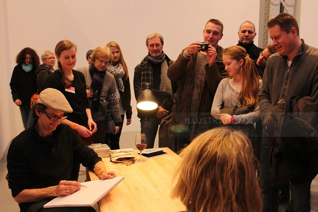 Author Björn von Schlippe signing books as fans watch and photograph